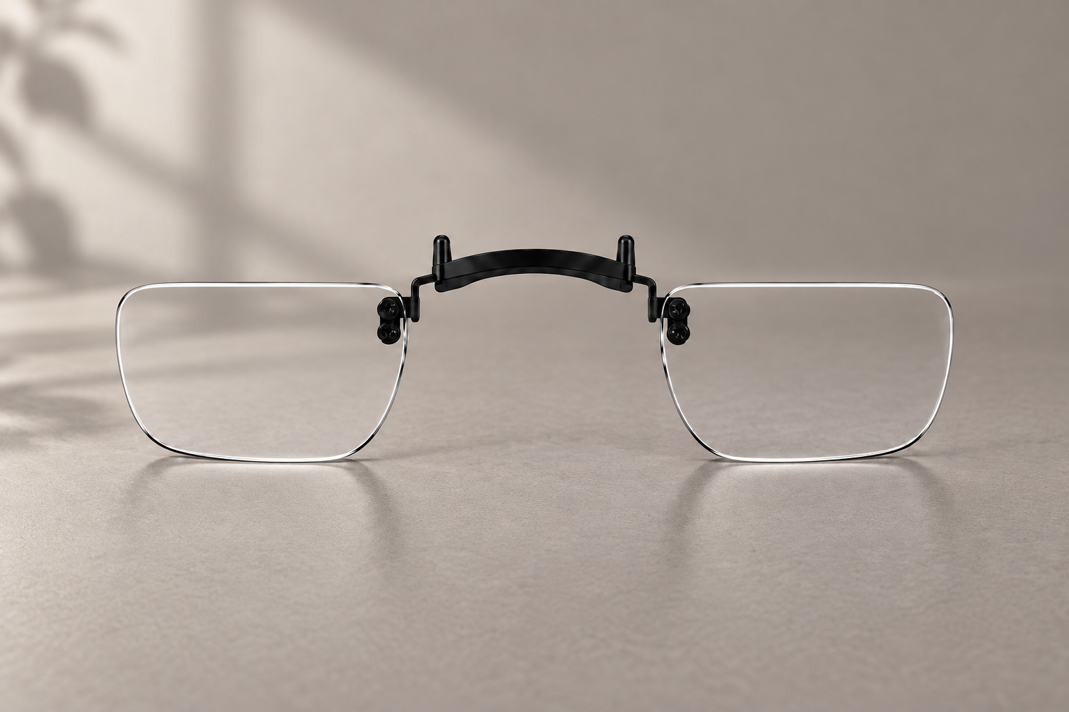 Clear XREAL One Pro lens insert with a black bridge against a neutral workbench backdrop.